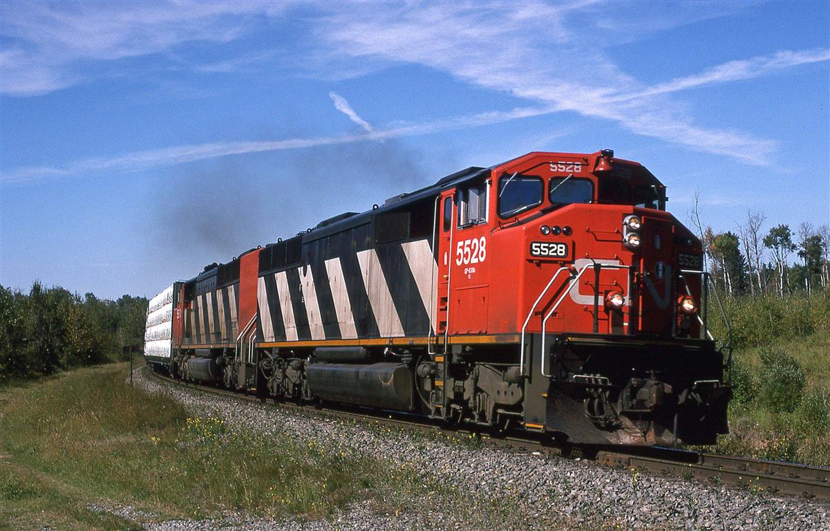 358, carrying wood products from Prince George BC, rounds a curve near Seba Beach. These heavy trains usually had 2 or 3 large locomotives for power.