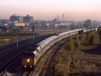 I think that this is a photo of the "Canadian" arriving in town. It has left the main line ( seen as a distinct line in front of the elevator and yellow building), and is now on the stub track leading to the downtown station. The LRT tracks are adjacent to the CN track.