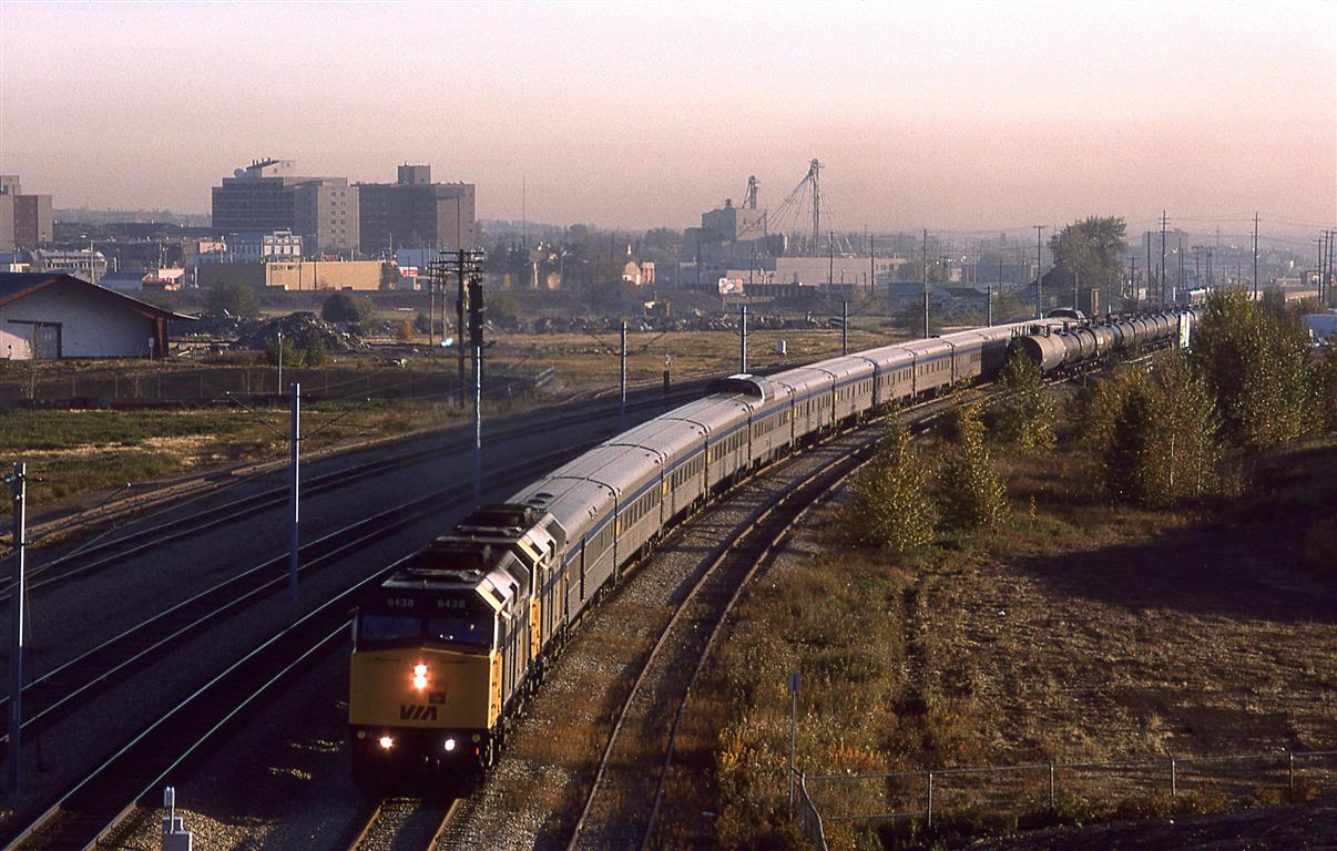 I think that this is a photo of the "Canadian" arriving in town. It has left the main line ( seen as a distinct line in front of the elevator and yellow building), and is now on the stub track leading to the downtown station. The LRT tracks are adjacent to the CN track.