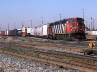 One of the few places where I could photograph Walker yard was behind "Sport Check", a sporting goods store, at 82 street. this is the east end of the (now former) intermodal yard.
444 was the daily train to Calgary. It left each morning around 0800 hrs. It was kind of a treat to have a GE on the lead at the time.
The track closest to me is the yard bypass. I believe that it is now double track.