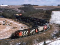 One of the coolest spots in Edmonton to photograph trains is the the Westlock Sub near Carbondale. I studied the topo maps and later learned to listen to the radio, where engines coming off the shops would speak with the switchtender to learn where their train was located. This meant that I had about an hour to get into position. We bundled the kids up into the car and my wife drove us north of town.
806, being a grain train wasn't predictable, but trains tended to be "bundled" around the comings and goings of the regular freight trains 418 and 419. I cannot remember if that was the case this day. I would doubt it though, based on the sun angle. This train is bound for McLennan. In 1995, only light 4 axle (and a few ex NAR SD-38's) plied these rails. I understand that this is longer the case. CN is running much bigger power up that way now.