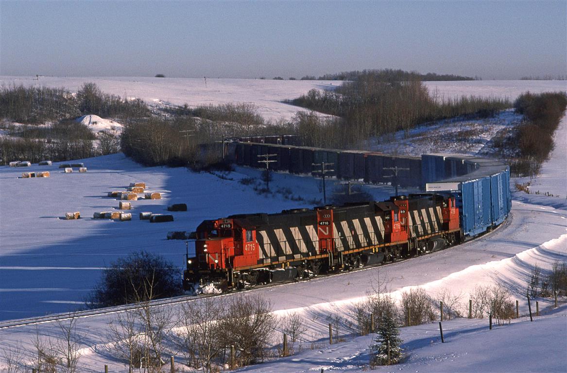 Judging by the shadows, I am thinking that this was taken around 1400 to 1500hrs. I could have used some snowshoes for this trip, but my Sorels worked just fine (I still own those boots). At least, I seem to recall that I did not have to wait very long for it to arrive.
There appears to be an interesting assortment of cars in the consist.