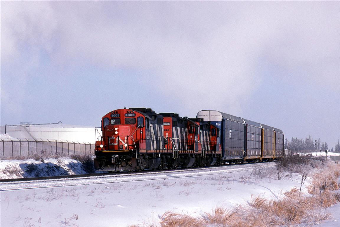 Steam from the nearby Celanese plant whitens the sky on an otherwise clear day. The Clover Bar Transfer has a few auto racks in tow to bring to Walker Yard from Clover Bar Yard. The cars may have come from the auto handling facility near Clover Bar, or they arrived on a train that dropped them at Clover Bar Yard, and will go out on a train from Walker.