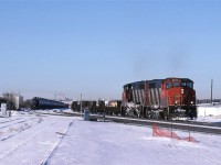 This temporary curve is a shoe-fly track put in to allow for the construction of the 50th St underpass.
The proper alignment may be seen at left.
I do not know why the string of tanks cars are parked here. Storage? Set out for pickup by a specific train?
122 will have nothing to do with the tank cars. It is a priority COFC train.