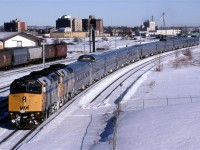 After the station stop in downtown Edmonton, the train back to East Junction, where it acquires the main line. It will then continue west.
The Sun seems to have melted a significant amount of ice from the sides of the train.
The grain cars may have been delivered to an small elevator behind my position.