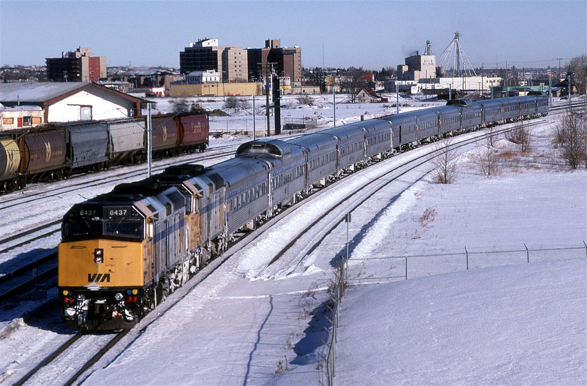After the station stop in downtown Edmonton, the train back to East Junction, where it acquires the main line. It will then continue west.
The Sun seems to have melted a significant amount of ice from the sides of the train.
The grain cars may have been delivered to an small elevator behind my position.