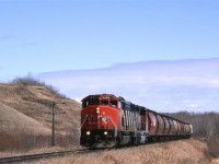 This is another area that I found by studying topo maps. The Camrose Sub winds down this valley from the town of Camrose to cross the Battle River Valley. My hopes were that I could obtain a view looking up this small valley from the south rim of the Battle River Valley. Trees and houses precluded that plan. I always wanted to explore this small valley for photo opportunities. I will manage to see the upper end but I was not able to really get to know the bottom  area. There are several wooden trestles in this small valley.
Ferlow Junction, in the Battle River Valley is where a branch splits off the Camrose sub. The branch, whose name escapes me, went to Stettler and may have been spun off to a tourist line at this time.
As for the train, it is an Edmonton to Calgary grain Empty. Presumably, cars were dropped at elevators on the way to Calgary, and picked up on the way back north