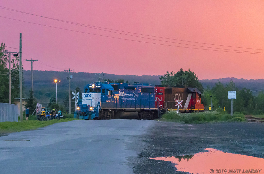 CN local L578 heads into a spur to do a pick up of a cement car at sunset. The Grand Falls locals are perched near the tracks on their 4 wheelers.