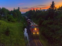 In day's last light, train 406 descends down the grade at Quispamsis, about 8 miles east of Saint John, New Brunswick. It was about a three mile uphill climb, cresting about a mile from my location. With a train of mostly empties, it wasn't a huge challenge. 