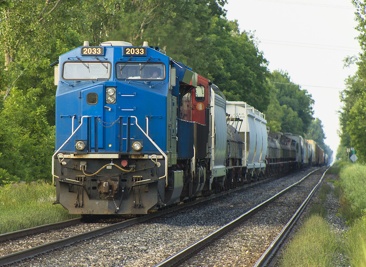 As most of us living in Southwestern Ontario experienced, we saw the increase of rerouted trains due to the Sarnia Tunnel derailment that occurred at the end of June. Here, in Chatham most rerouted trains would sit for hours on end on the outskirts of town as the Chatham Subdivision was only single tracked from 'Chatham East' all the way to Windsor. Add this with the eight VIA trains that stop in Chatham, it was quite congested between both  the rerouted traffic going both east and west. 


Here, leased unit 2033 leads CN 367 west to Windsor. Well, it will as they sit and wait for eastbound reroute CN 324 and the two VIA's on this wonderful Sunday evening in early July. To make this night even more better, after taking this photo I had a half hour conversation with the conductor at the Hwy 40 crossing.