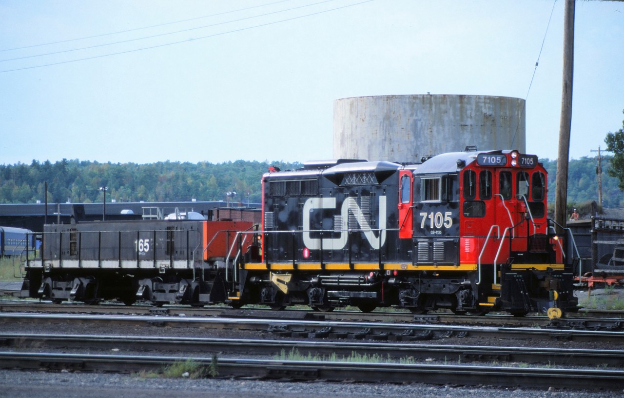 CN 7105 and 165 work the yard in Capreol, Ontario on August 3rd, 1987.  The 7105 had been recently rebuilt from SW1200RS 1253.  The 165 began life as S-3 switcher 8487, rebuilt to yard slug B-5 (you can see this number bleeding through the paint).  It was then renumbered to 304 and finally 165.  The 165 is being used solely for extra breaking capacity at this time.