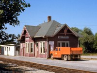 CN's Milton Station is pictured in 1973 at its original location, along the former mainline that at the time of this photo was now a short spur.<br><br>The CN line through Milton was originally built as the Hamilton & Northwestern Railway, eventually becoming CN's Milton Subdivision. The line, which crossed CP's Galt Sub at an interlocking diamond north of the station, was grade-separated and realigned to the west through town around 1963-64, becoming part of CN's new Halton Subdivision.<br><br>The old alignment became a short spur line, the Milton Townline Spur, that ran south to the old station area here to serve the Robertson Screw factory nearby. The CN-CP diamond was removed circa 1973-74, and CP then served Robertson Screw into the 80's via a connecting track off their Galt Sub to part of the former CN trackage. CN's Milton Station was moved to north end of town, and serves as a tourist information building in Chris Hadfield Park.