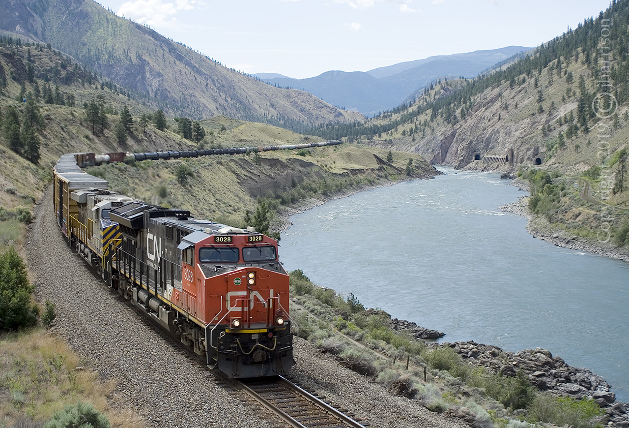 CN 3028 with the CREX 1517 heading east along the Thompson River at Drynoch - MP77 on the CP Thompson Sub. The Skoona tunnels - CN Ashcroft Sub, can be seen in the upper right of the image. 

GPS Approximate.