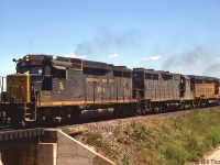 Working hard with extra flags flapping and no shortage of exhaust, Chesapeake & Ohio GP30 3004, GP35 3561, GP30 3022 and a CP 8100-series SW1200RS climb the grade at Kelso near the former location of CP "Christie" (Mile 35.8 to the west, removed from timetables sometime in the early 70's), heading a westbound CP freight on the Galt Sub on a sunny July day in 1979. <br><br> Power-short CP commonly borrowed C&O (and B&O) power at the time, typically GP30's, GP35's, GP38's and GP40's that were painted in the older blue/yellow or the newer Chessie paint.<br><br><i>More CP action around Christie/Kelso:</i><br>Steam-era climbing the hill: <a href=http://www.railpictures.ca/?attachment_id=28855><b>http://www.railpictures.ca/?attachment_id=28855</b></a><br>Leased B&LE power: <a href=http://www.railpictures.ca/?attachment_id=17031><b>http://www.railpictures.ca/?attachment_id=17031</b></a><br>F-units by the Kelso ski hill: <a href=http://www.railpictures.ca/?attachment_id=17335><b>http://www.railpictures.ca/?attachment_id=17335</b></a>