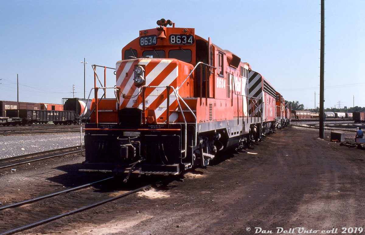 CP GP9 8634 heads up two hump sets, resting between duties at CP's Alyth Yard in Calgary Alberta. After the three remaining CP Train Masters were retired in the mid-70's, CP started using GP-F7B-GP sets for hump duties. By this time the F-units were getting long in the tooth and nearing retirement, and many of the B's ended their lives working in hump service. Older roadswitchers like the 8400-series GP7's also found their way into yard and hump duty.

Three chop-nosed GP9's (8633, 8634 & 8635) were regulars at Alyth Yard, having been chopped in the early 70's as an experiment for better visibility in yard service (they also had their dynamic brakes removed). Note the unique "pointed" chop nose that some of CP's early chops received (only 8633-35, 8530 and 8492), along with the EMD-esque front numberboard assembly that became standard on CP's later Geep rebuilt program.

While most of the F's would be retired in the early 80's, the GP7 and GP9 fleet would be rebuilt and continue on in yard and local service for another few decades. CP 8634 would be rebuilt as GP9u 1579 and keep working yard duties until being retired and sold to ILSX as their 1319, then to DLCX.

Keith Hansen photo, Dan Dell'Unto collection.