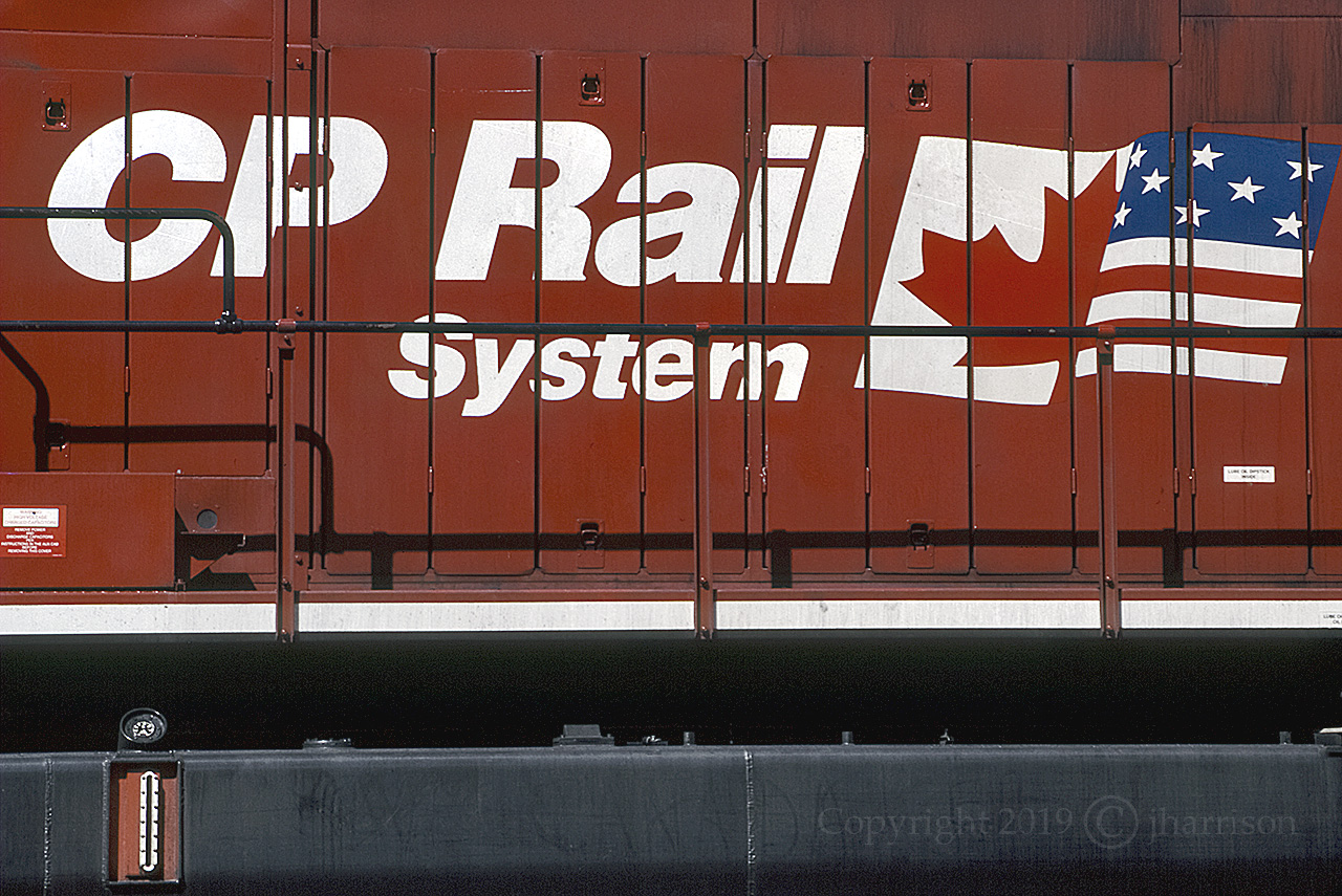 The dual flag logo on CP 9575 at Golden Yard - CP Windermere Sub in June of '97. The trailing unit was CP 9502, and much farther back - RCU 9548.