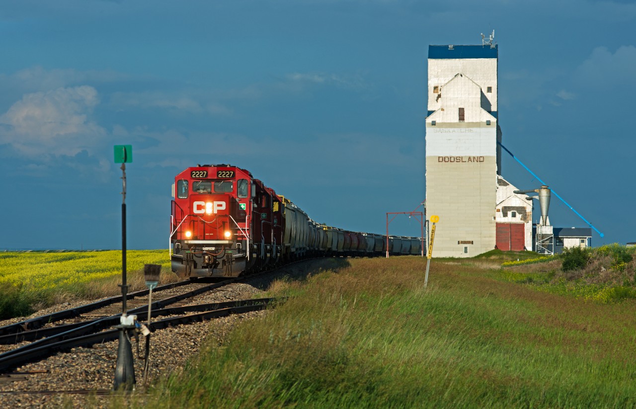 True Canadian branchline action at it's finest. With canola fields on one side and a grain elevator on the other, a trio of four axle power leads a grain peddler along 100+ year old jointed rail.