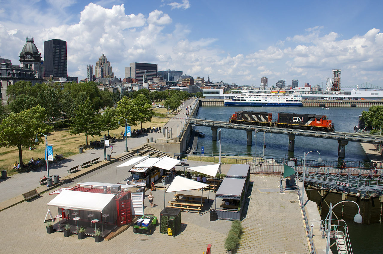 The Pointe St-Charles Switcher is heading light power to pickp up cars in the Port of Montreal with CN 4129 & CN 4700 for power. In the background the cruise ship Victory II is docked.