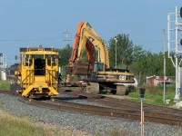 In connection to my photo of the 7227 waiting for permission to pass through a work area. Here is the reason for the delays at East Edmonton. For several days, to the right and out of sight in this photo, on the road to the diamond they constructed the new crossing. Just like the slow crawl when moving rockets out to the launch pad, the 2 backhoes did the same. You can see the new diamond suspended just below the buckets. I left shortly after this photo, it was a slow process. The 7227 has gone north and home and then 115 passed through going south several minutes before this moment. In the far distance to the left, you can see the red face of a CP engine. I suspect one more train passed through on the way to Fort Sask. before the dismantling of the old crossing began.