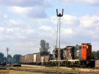 GTW GP9 4429 leads two CN GP9's at the head end of an eastbound freight flying white extra flags, heading through Komoka on the Strathroy Sub in September 1973.