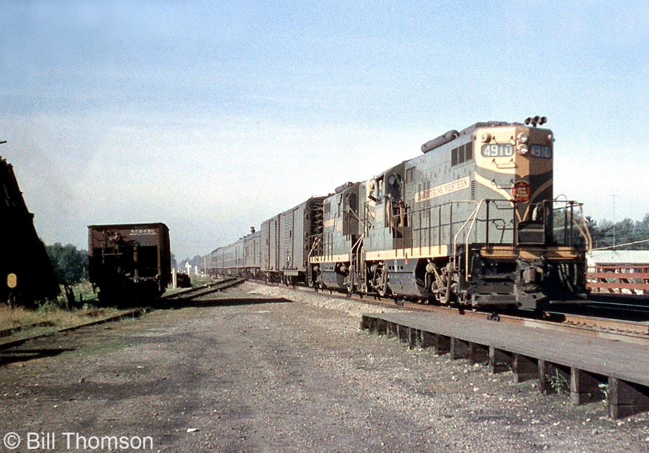 Grand Trunk Western passenger service "Torpedo Tube" GP9 4910 leads a sister unit eastbound through Port Credit in 1958, on train #14 the morning "International Limited" from Chicago for Montreal via Toronto. Note the boxcars on the head end, one being an "automobile boxcar" equipped with end doors for easier automotive loading.  Unlike Canadian parent CN that preferred using steam generator cars when using GP and RS hood units on passenger trains, the GTW purchased a handful of GP9's specially equipped with steam generators, water tanks and rooftop-mounted air tanks for passenger service, and numbered them in their 4900-series. More at Port Credit:RDC's at Port Credit Station: http://www.railpictures.ca/?attachment_id=21410CNR 6070 at Port Credit Station: http://www.railpictures.ca/?attachment_id=24345Doubleheading Northerns crossing the Credit River: http://www.railpictures.ca/?attachment_id=24345