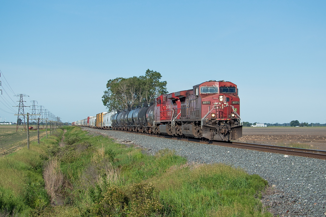 Early on a Saturday morning, an eastbound rolls through the open landscape of Chatham-Kent. I had a lot of time to choose this spot, as I heard RTC tell 8571 East that they could proceed from Belle River once the westbound I had just seen in Chatham had cleared. I chose this spot because it was wide open and as quiet as could be - I didn't see another person or car for the entire time I was waiting here.
