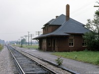 Built in the 1900's at the CP Mactier Sub crossing of Nashville Road, this CP No. 5 station design replaced an 1869 Toronto Grey & Bruce Railway structure. The station name is Kleinburg, though old Kleinburg is about 3 km away on far side of the West Humber River valley - this location is much closer to Nashville ON. Picture was taken not long before the building left this spot.<br><br>
My reference says CP trains last stopped at the station in 1964, from then until 1976 the station was a (rented?) residence. By 1976 CP wanted Kleinburg station gone - I recall hearing that CP agreed to sell it for a nominal amount, on the condition that it be removed from CP property.<br><br>
The station was purchased, and the structure was transported (as intact as was practical) to a new location at the north-west corner of the Kleinburg Public School grounds. Because of wires across the route, the roof and upper parts had to be removed. After its arrival, a foundation was made for the structure and the station was nicely restored, including station name signs, a baggage cart, and a semaphore signal. The brick chimneys did not survive, looks like gas heating now.