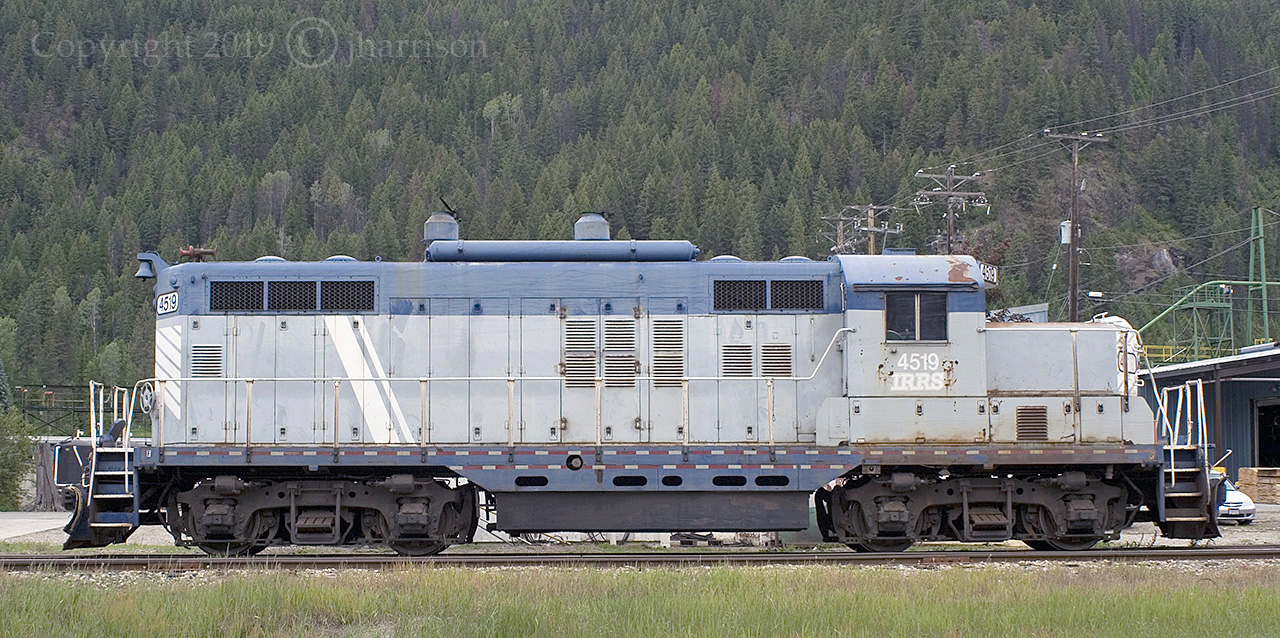 From another point of view: The ex GTW & IRRS EMD GP9 4519 was built in 1957. First numbered GTW 4919, the now Nelson and Fort Sheppard 4519, since 2012, is seen here shutdown in the siding at the Atco Wood Products mill in Fruitvale B.C. The mileage listed on the cross bucks at the entry crossing to the mill reads 149.91. At one time the unit delivered product from the mill to the U.S. border where there's a connection with the BNSF Nelson Sub. It might still but there are signs that the 4519 hasn't moved in a very long time. 

By coincidence there's a photograph by another photographer at another website dated 8/21/2018 that was taken from this exact vantage point. That photo is minus the car in the parking lot seen at the bottom front end of the unit, indicating that it probably hasn't moved in a very long time. The GPS reading for this photo is pin pointed on the roof of the unit.