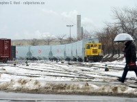 While John Pittman posted a great photo of a critter that has not been seen (new to me!) I figured I'd pull this out to add to the critter pile.<br><br>
I present this offering taken on a moody dreary day, back then I was sick of them but now given the current summer heat as I post this in July 2019 this doesn't look too bad does it..<br><br>
It's only every so often that a car builder like NSC builds cars for a Class 1 that are immediately recognizable. So I  went over there to shoot what was on hand, and finding this switcher working was a real bonus. Then  a  NSC employee  walks into the frame with an umbrella... I snapped a frame really quickly knowing it had to be right there and then and this is the result. 