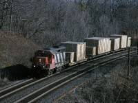 In early morning sunlight, standard cab GP40 locomotive CN 9312 leads a short train of 3 flatcars loaded with large wooden crates, contents unknown. <br>
The crates look large enough for this to be a "dimensional" train. "Do Not Hump" can be seen on some of the crates.<br>
The train is westbound on the CN Oakville sub north track approaching CN Bayview (Junction); vantage point is sidewalk of Plains Road (Wolfe Island bridge).<br><br>

Only 1 of the 2 "Extra" lights above 9312's number boards is illuminated, several other pictures by Bill also show just 1 of the 2 illuminated.<br>
CN 9312 was built in 1967 by GMD London, original number CN 4012. The 4000-series GP40's were renumbered as 9300's in 1981, below the GP40-2(L)W range starting at 9400.<br>
