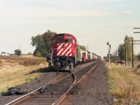 MLW C424 CP 4239 is leading its train onto the main line, at a passing track in the countryside east of London ON.<br> The crewman boarding the engine looks cheerful. <br> Note the reflection of the diagonal stripes on the right rail near the switch point. <br> The front of the engine of another train can be seen further down the siding. <br><br> CP did not show the mileage on the back side of this signal, so location wasn't easy to determine.<br> Guided by Mr. Noe's comment and online map tools - this is a westbound train on the Galt Sub exiting the west end of Nissouri siding, as seen from Purple Hill Road grade crossing.