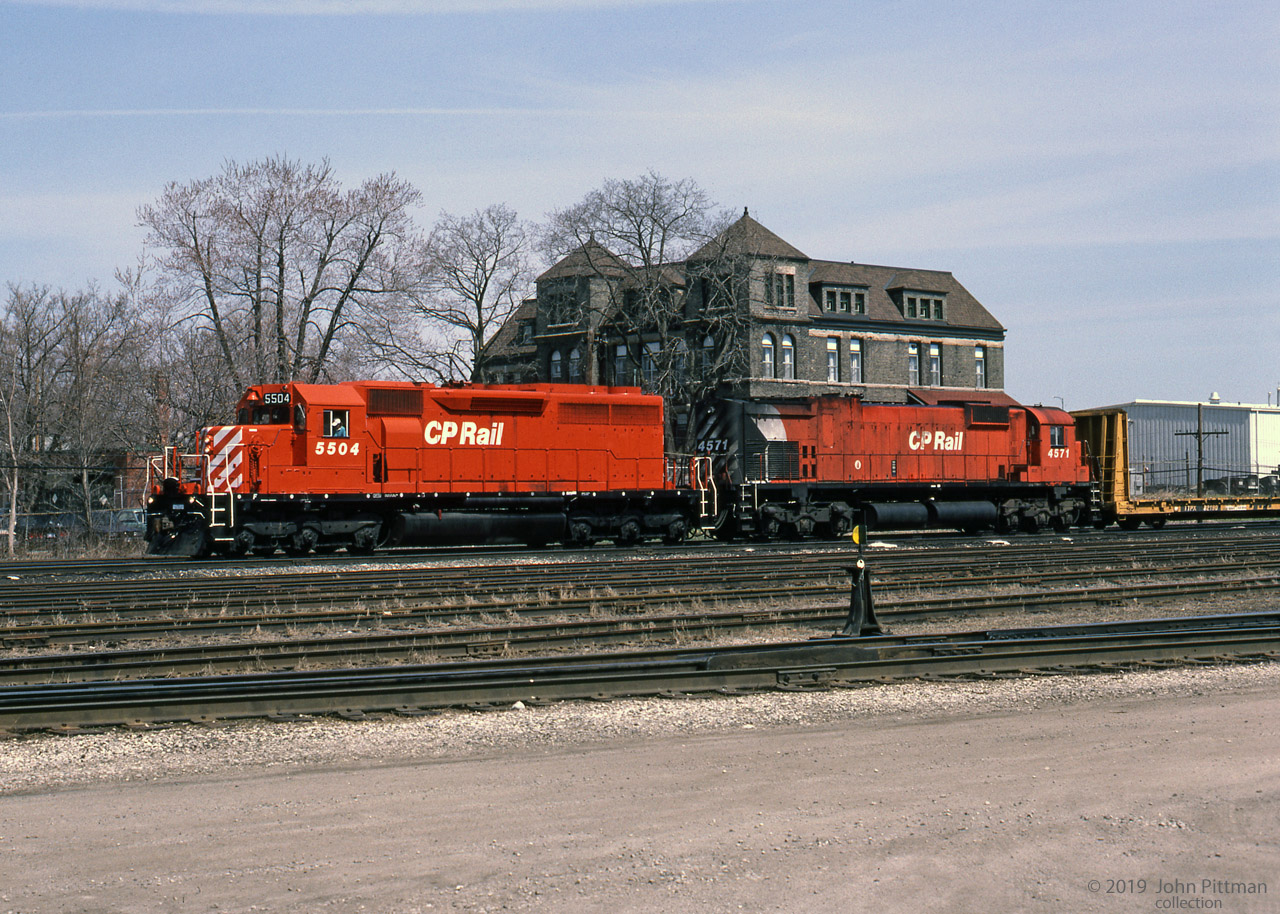 A pair of 3000 HP locomotives with train, CP 5504 (GMD SD40 built 1966) and CP 4571 (MLW M630 built 1969). 
Halted near the west end of CP's Quebec Street Yard in London ON, the crew could be awaiting a signal to proceed west to Windsor.