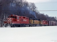 Remanufactured GP9u units CP 8239 and CP 8207 bracket a leased ex-UP SD40 HLCX 3015 in this February 1994 scene at Kinnear yard.<br>
Three of the head-end boxcars of this southbound train have Conrail markings.<br>
Fresh snow does not make the ascent of the Niagara Escarpment to Vinemount any easier.
	
