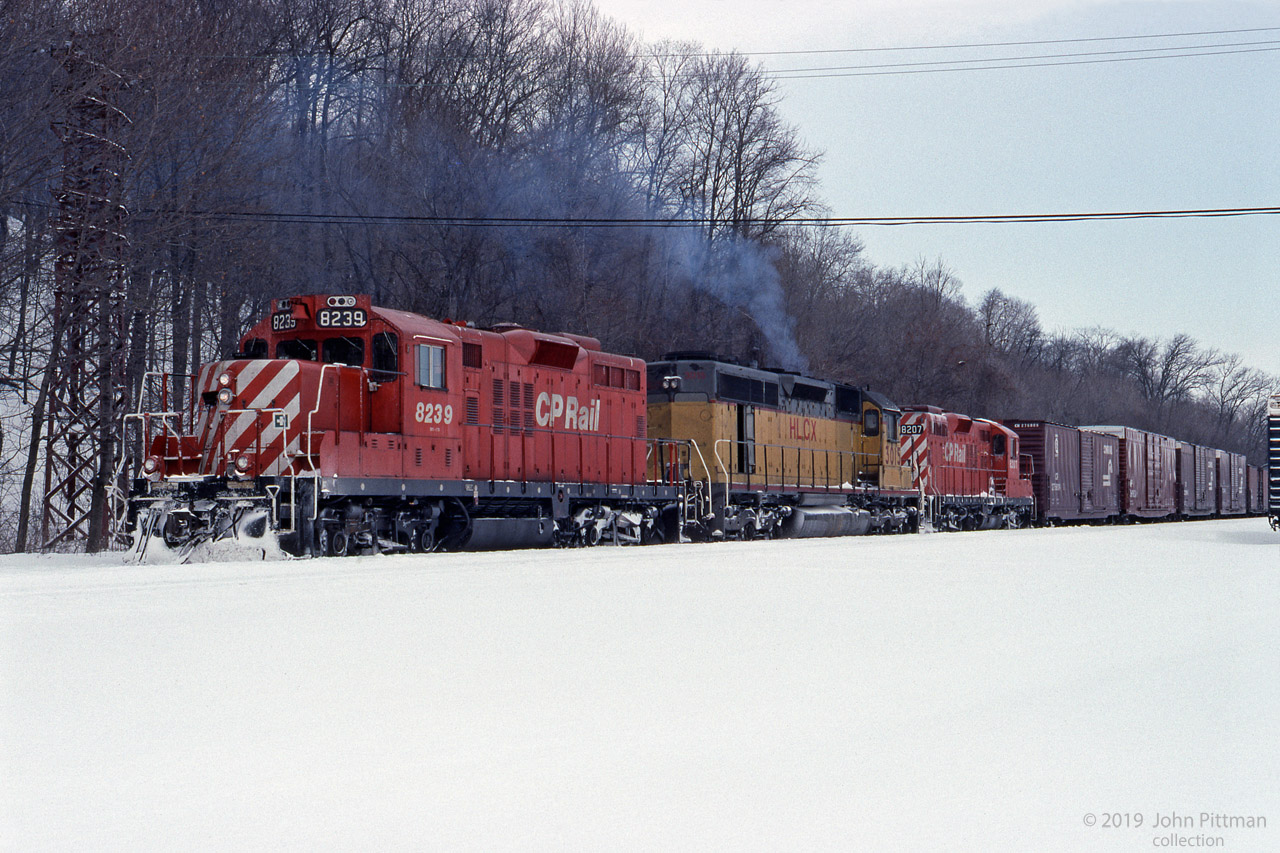 Remanufactured GP9u units CP 8239 and CP 8207 bracket a leased ex-UP SD40 HLCX 3015 in this February 1994 scene at Kinnear yard.
Three of the head-end boxcars of this southbound train have Conrail markings.
Fresh snow does not make the ascent of the Niagara Escarpment to Vinemount any easier.