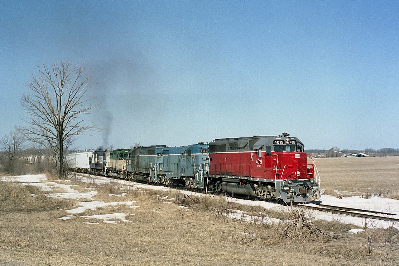 Its early spring and a nice day as a southbound GEXR salt train powers up as it leaves Goderich for Stratford. Although this image is but 20 years old, times have certainly changed on the railroad. For one thing, all the power has long departed. Seen are GEXR 4019, 4161, 3834, 177 and Georgia Southwestern 2127. The scene is on approach to popular Black's Point Rd, a shortcut to a nice swimming beach from Hwy 8 to the lake. At least it used to be. High water has killed many beaches along Lake Huron this year.
Disposal of power...4019 to OVR 2009, 4161 (slug)scrapped 2008, 3834 (slug-mother)scrapped 2013, 177 scrapped 2008 and the GSWR 2127, which in this image looks like it is carrying the load, scrapped 2008.