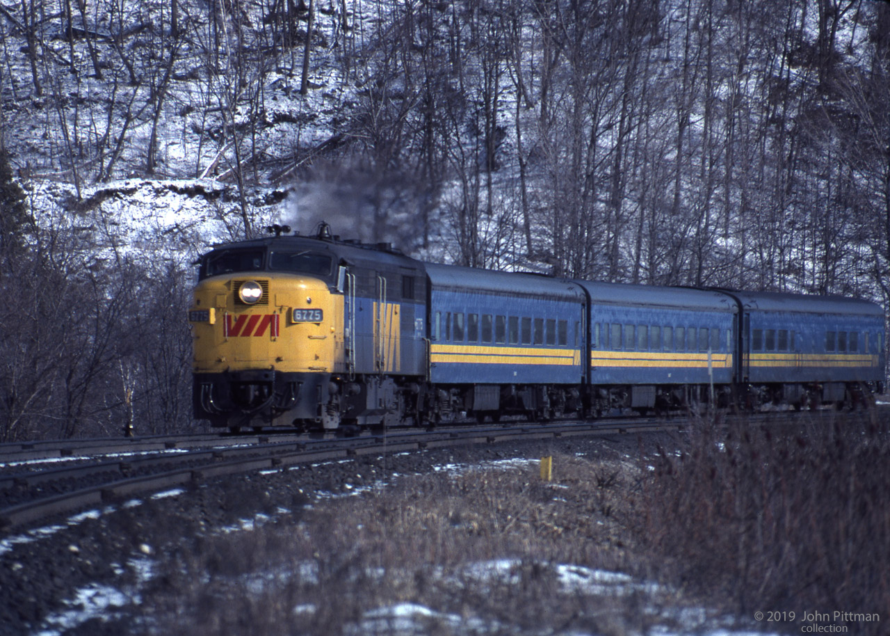 MLW FPA-4 VIA 6775 powers itself and 3 steam-heated coaches of its westbound train up the grade below Dundas Peak, approaching Dundas Station. I read that Dundas Station was severely damaged by fire in 1984.
MLW built and sold 34 FPA-4 (A-unit) and 12 FPB-4 (cabless B-unit) locomotives to CN alone, who transferred them to VIA. Their CN / VIA class codes were MPA-18a and MPB-18a.
A 12 cylinder 1800 HP ALCo 251 diesel engine improved on the 1600 HP ALCo 244 engine of the FPA-2 (and FPB-2).