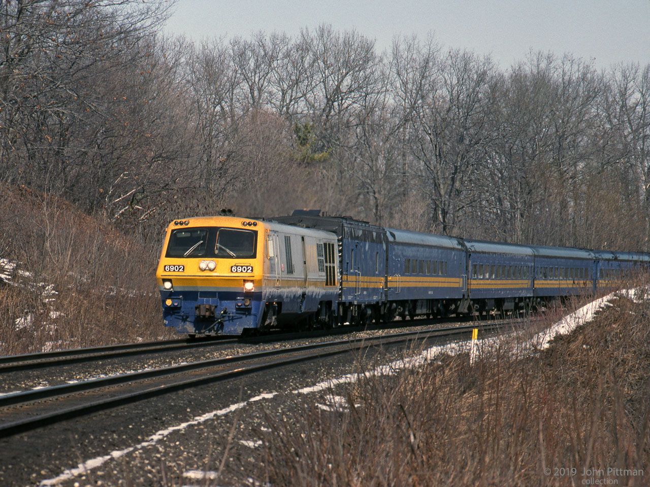 Westbound LRC-2 locomotive VIA 6902 leads its train of steam generator unit and steam heated coaches on this March 1990 morning. This was 2 years before the entire LRC coach fleet was taken out of service for wheelset replacement. 
A few tenths of a mile ahead the train will cross the Burlington/Hamilton boundary and switch onto CN Dundas Sub at CN Bayview en route to Windsor.