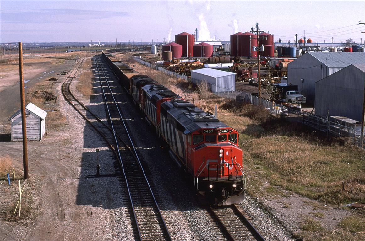 716, an empty sulpher train heads south out of Edmonton on the Camrose Sub. It is headed to Ram River via the Brazeau Sub. Apparently these sour gas field that have the hydrogen sulphide stripped and reduced are still going strong.
My wife and kids are on this chase, therefore we did not get much beyond Camrose. Note how sunny that it is.