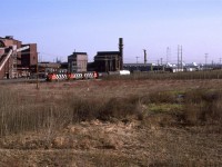 This was an attempt to put the capture the RR "in place", or in its environment. 
550, the Brazeau Sub local is leaving Edmonton, and passing the distinctive Stelco (?) works. This facility is Alta Steel now, with a different building setup.
The spheres and distillation towers in the background belong to the Imperial Oil refinery.
Although not in the photo, 90 degrees to the right, there was a safety training facility that had a caboose high up on a metal bridge to nowhere. Sorry, no photos.