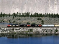This was another area that I spotted on topo maps, and finally the opportunity came up to see it in person. I walked from Walhachin to Savona. 
The tracks use this causeway to cross an oxbow lake (remember your high school geography class?), with the Thompson River up against the slope in the background. (Given the topography of the area, it is actually quite unusual that such a lake would form in the first place.)
So, another manifest train heading west with lumber up front. 
