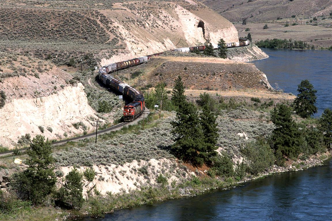 This westbound grain train skirts First Nations' land, and the Thompson River which it will cross in a moment.
The 2400 leading is using the "Canadian air conditioning".