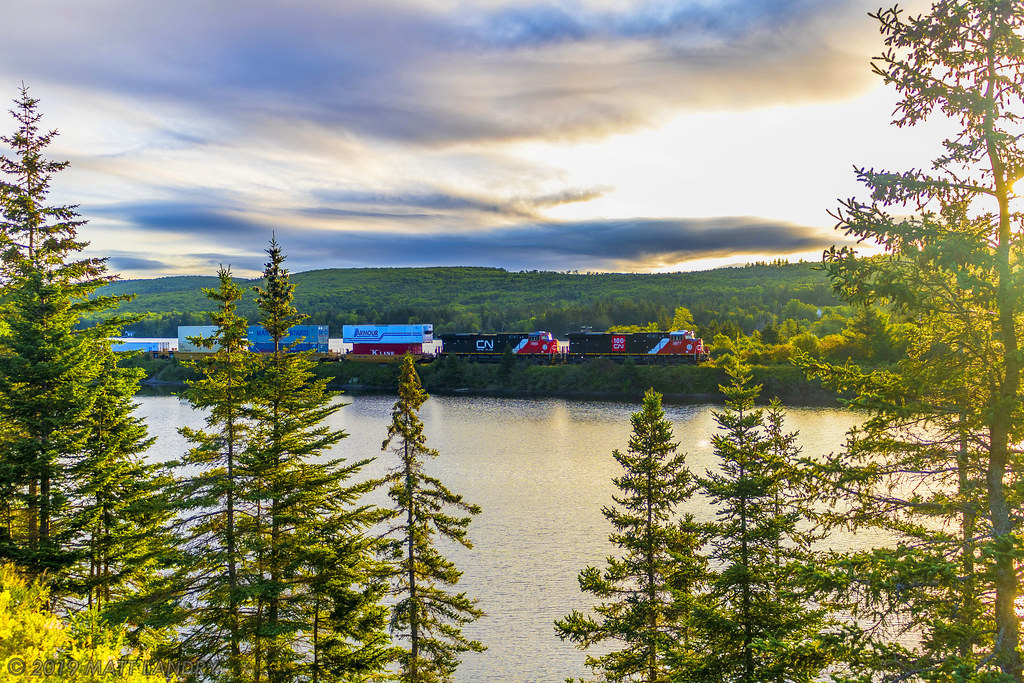 During a beautiful sunrise, stack train Q120 heads through the scenic Folly Lake, Nova Scotia.