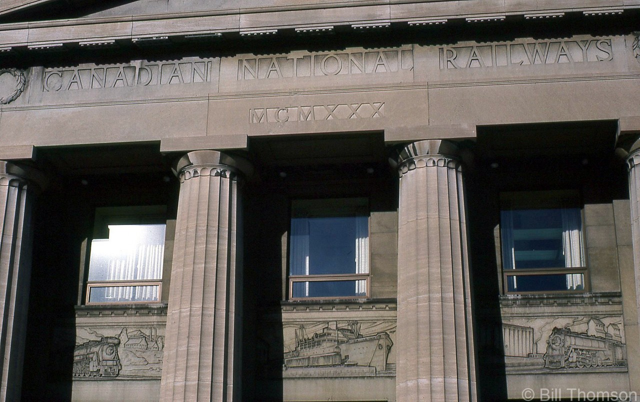 A closer look at some of the lettering and images over the main entrance of CN's Hamilton (James Street) Station, including carved murals in the stone of CN steam engines and railway equipment in various industrial, prairie and port scenes. MCMXXX is 1930 in Roman numerals.