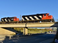 After having just finished spotting a long stash of empty autoracks into Chrysler, CN 579 is seen slowly creeping over the Airport road overpass at the end of the North Park Spur as they prepare to run light back through BIT in order to re-couple on to the loaded autoracks which they pulled a couple hours earlier. Timing is 07:24. Generally this local will be nocturnal for the most part as crew is scheduled to go on duty at 23:30 in MacMillan Yard but every so often comes the odd morning when they are still operating under first rays of light (especially this time of year) and I guess I just happened to pick the lucky morning today! Power is CN gp40-2 4713, gp9rm 4028 and out of sight, GMD-1U 1439 + gp9rm 4130. 