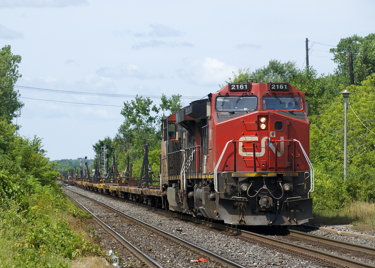 CN X388 with CN 2161 & CN 2236 for power is stopped just west of Dorval Station, awaiting its signal. This train consists of 72 cars for loading windmill blades and will terminate in nearby Taschereau Yard, with the cars continuing to Joffre Yard as part of the consist of CN 400.