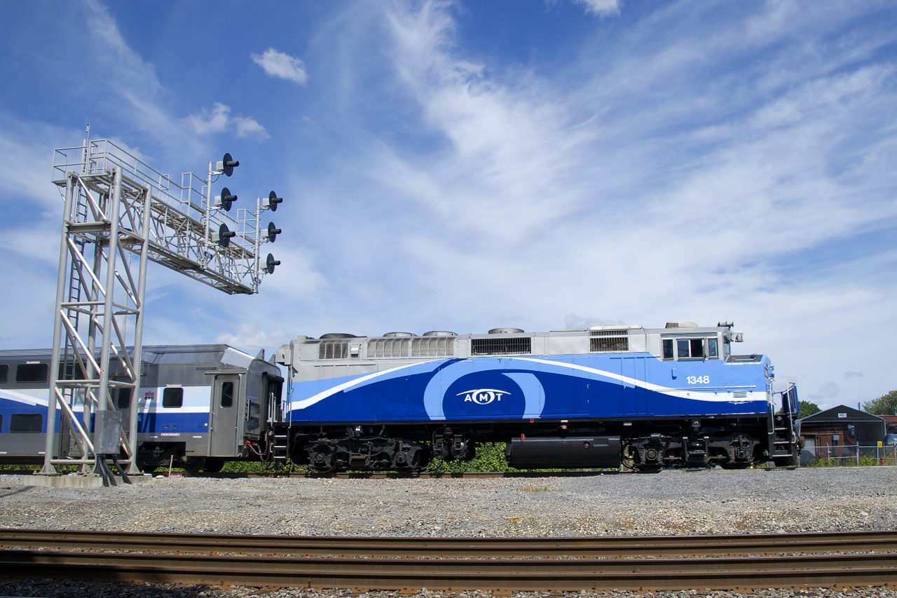 AMT 1348 leads EXO 60 under a signal gantry after making its stop at Dorval Station. In the foreground is CN's Montreal Sub.