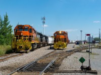 Quebec Gatineau's freight from Trois-Rivières and St-Luc Yard has arrived at the Ste-Thérèse Yard with QGRY 3347, QGRY 6913, QGRY 6920 and 81 cars as the westbound turn for Gatineau prepares to leave at right with QGRY 2004 and 45 cars.