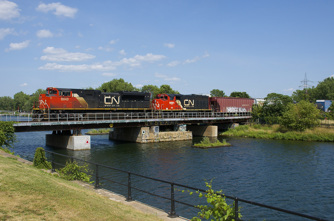 CN 527 with CN 8849 & CN 9591 for power advances over the Lachine Canal after dropping off part of his train on the Butler Spur. Soon he will be back up over the canal with cars to both set off and lift in Pointe St-Charles Yard before he heads to Taschereau Yard.