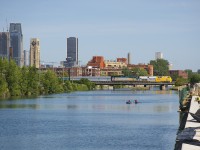 VIA 24 has VIA 920 (in 'love the way' wrap) and VIA 6438 for power as it crosses the Lachine Canal as a pair of kayakers head west on the canal. At right work continues on rebuilding the southern retaining wall.