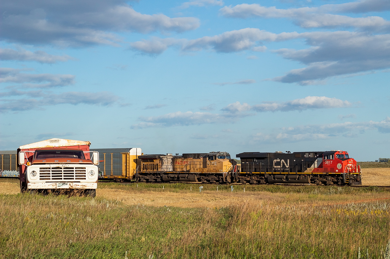 A westbound grain train was coming out of Saskatoon, and 401 was coming right behind, so I went west of town to what I thought was a nice bend on the Watrous Sub just southeast of Asquith and awaited both. Wouldn't you know it though, clouds impeded shots of both trains. Not wanting to come away empty handed, I followed the grid roads in an attempt to get out ahead of 401 to try at it again. I figured it wouldn't be too hard, both it and the grain train weren't moving all that fast. The grain train was in excess of 11,000 feet (two head end Tier 4s, 175 loaded hoppers, and a mid-train DPU Tier 4 in there somewhere) and 401 was a not-too-shabby 10,864 feet itself. I wasn't overly happy with the subsequent vantage points I came across until I saw this truck, and I knew right away that I found my spot and what the shot would be - it was just a matter of hoping the clouds would cooperate this time. Not pictured, but certainly adding to the whole experience, was two cows which had gotten out from a nearby farm who were standing on the road a couple hundred feet behind me just staring blankly at me.